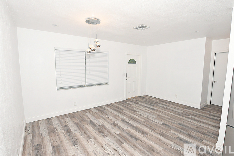 A room with wooden flooring and white walls.