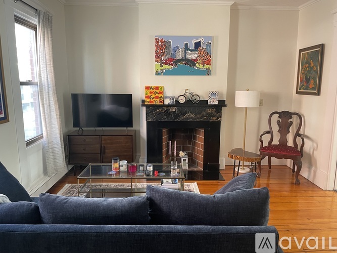 A living room with a fireplace and a painting on the wall.