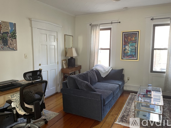 A living room with a grey couch and a black chair.
