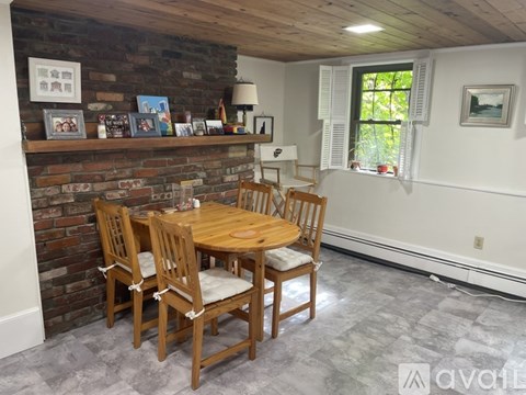 A dining room with a wooden table and chairs.