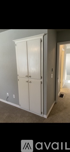 A white double door wardrobe in a room.