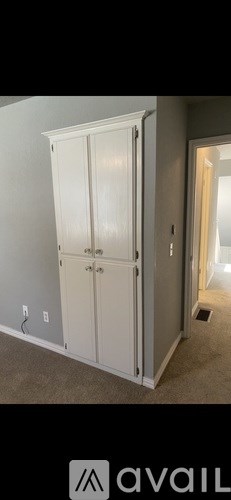A white double door wardrobe in a room.