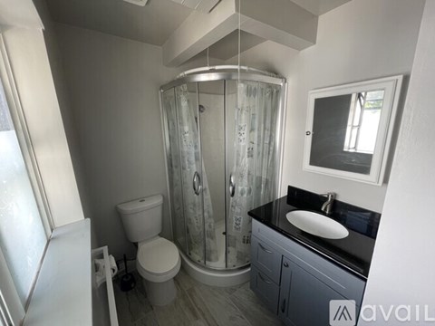 A bathroom with a toilet, sink, and shower.