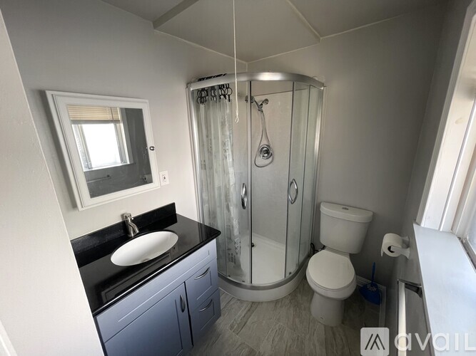 A bathroom with a sink, toilet, and shower.