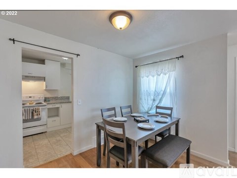 A kitchen with a table and chairs in front of it.
