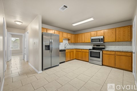 A kitchen with wooden cabinets and a refrigerator.