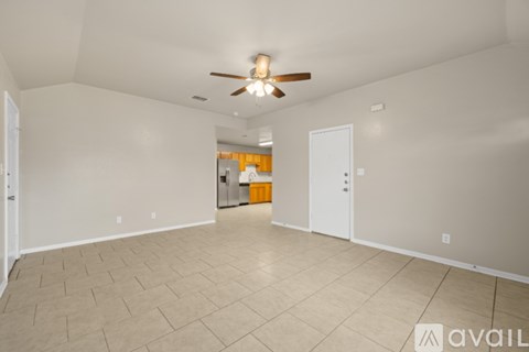 A spacious room with a ceiling fan and tiled flooring.
