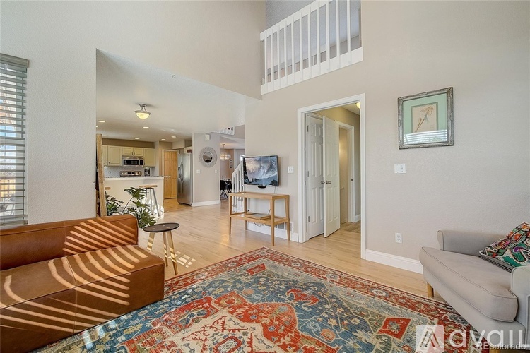 A living room with a brown couch and a rug.