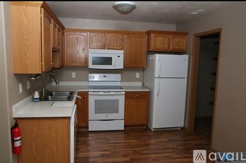 A kitchen with wooden cabinets and white appliances.