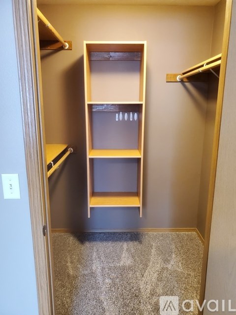 A small, empty closet with a single shelf and a door.