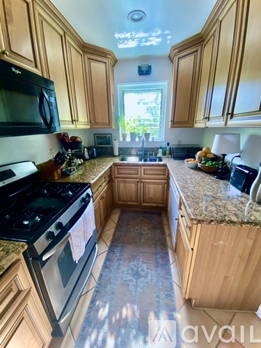 A kitchen with wooden cabinets and granite countertops.