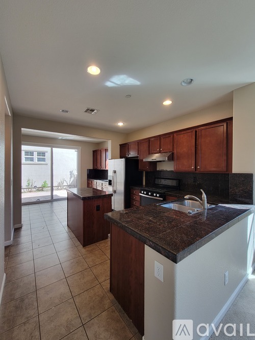 A kitchen with brown cabinets and a white refrigerator.