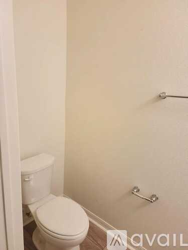 A white toilet is in a small bathroom.
