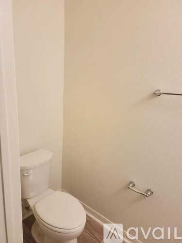 A white toilet is in a small bathroom.