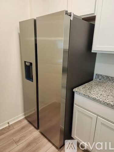 A stainless steel refrigerator with a water dispenser on the door.