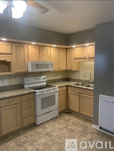 A kitchen with a white stove and oven, a microwave, and a washing machine.
