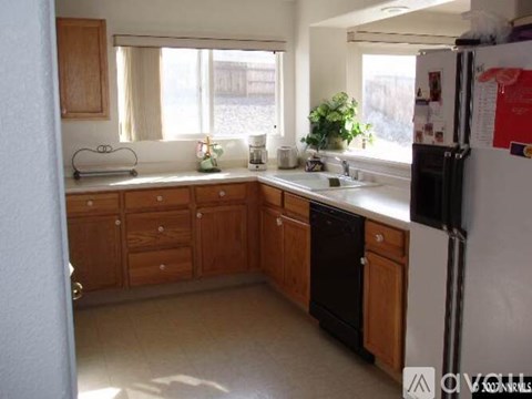 A kitchen with wooden cabinets and a white refrigerator.