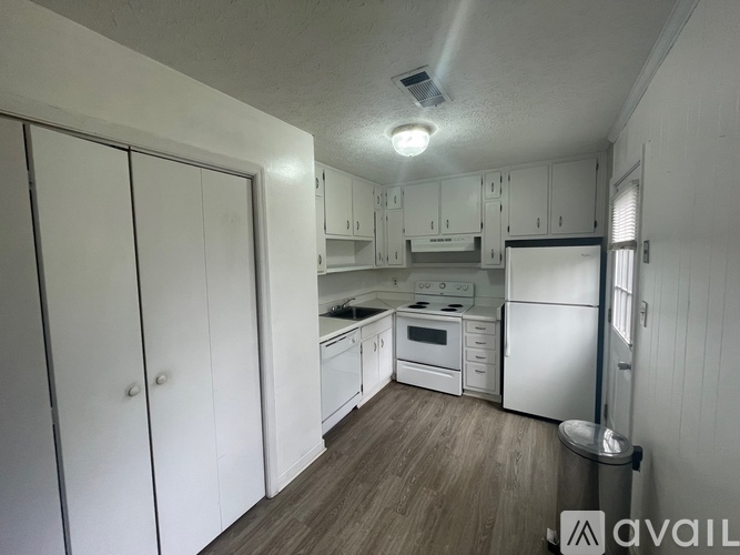 A kitchen with white cabinets and appliances.