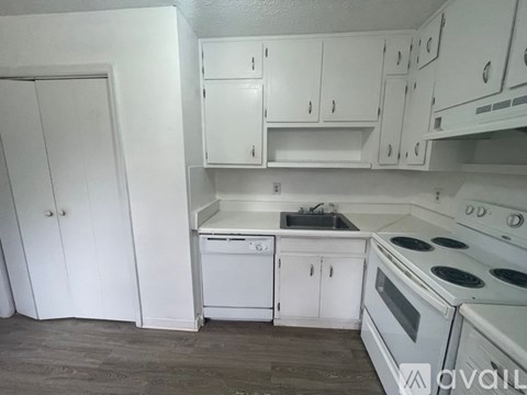 A kitchen with white appliances and cabinets.