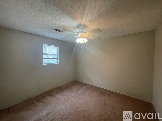 A room with a ceiling fan and a window.