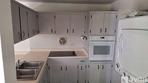 A kitchen with white cabinets and a stainless steel sink.
