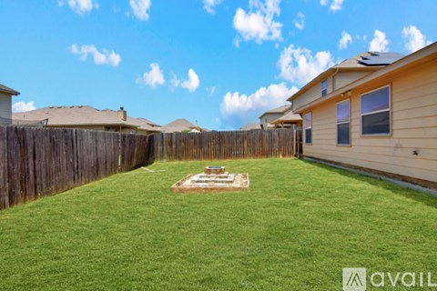 A backyard with a wooden fence and a small garden.