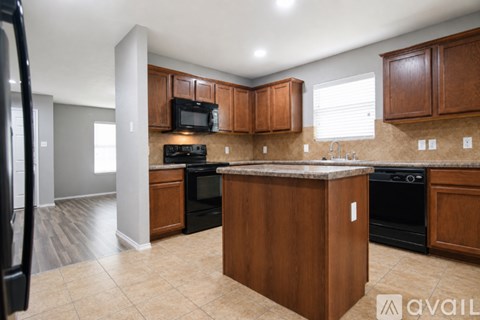 A kitchen with wooden cabinets and black appliances.