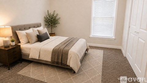 A cozy bedroom with a large bed and a small potted plant.