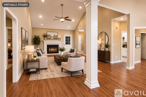 A living room with a fireplace and a ceiling fan.