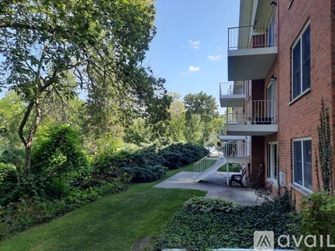 A balcony overlooks a green lawn and trees.