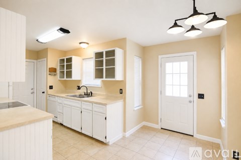 A kitchen with white cabinets and a sink.