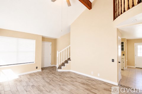A spacious room with a staircase and a window.