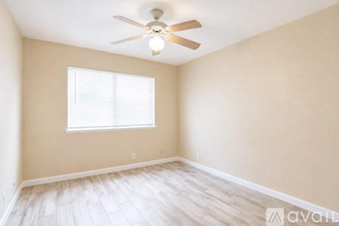 A room with a ceiling fan and a window.