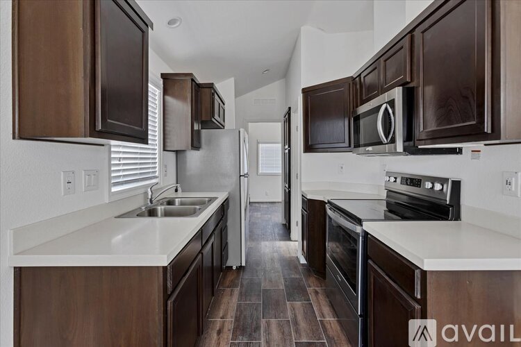 A kitchen with brown cabinets and a white counter.