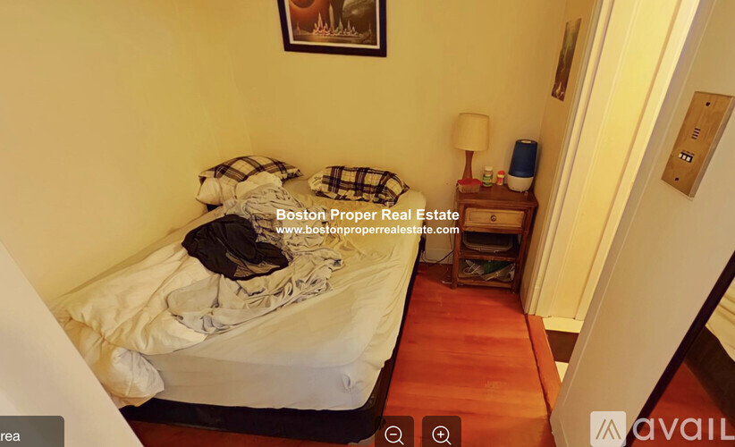 A bedroom with a bed, nightstand, and lamp.