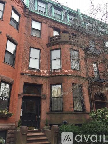 A building with a sign that says "Boston Proper Real Estate.".