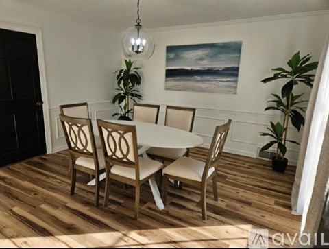 A dining room with a round table and chairs.
