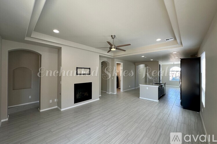 A spacious living room with a fireplace and a ceiling fan.