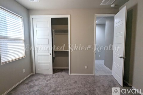 A bedroom with a white door and a carpeted floor.