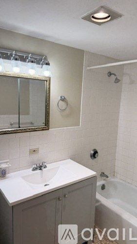 A bathroom with a white sink and a bathtub.