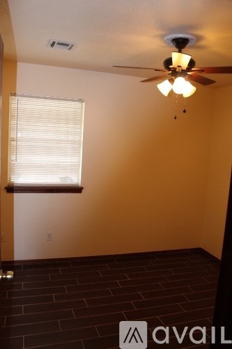 A room with a ceiling fan and a window with blinds.