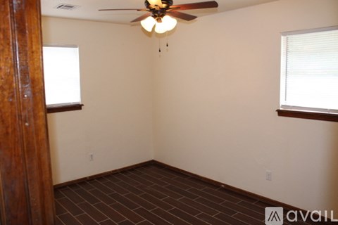 A room with a ceiling fan and brown tile flooring.