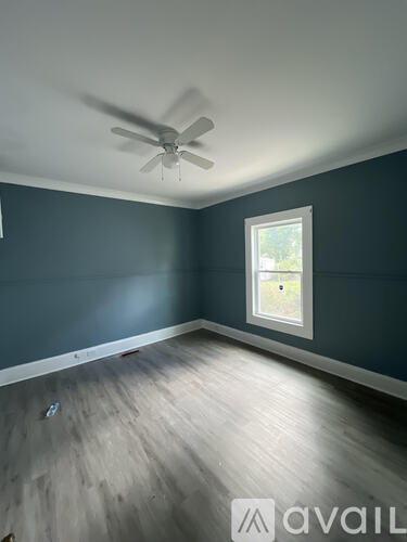 A room with a ceiling fan and a window.