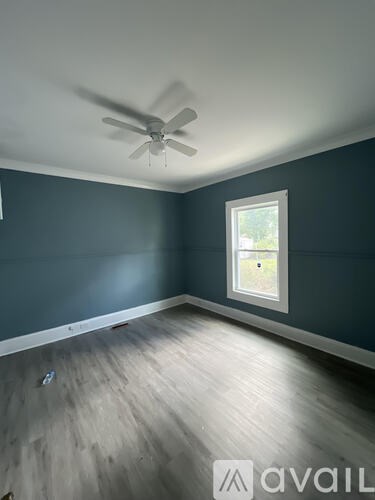 A room with a ceiling fan and a window.