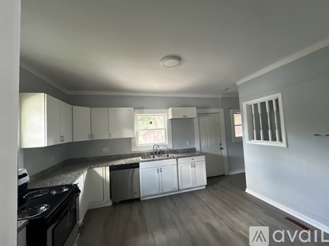 A kitchen with white cabinets and a black stove top oven.