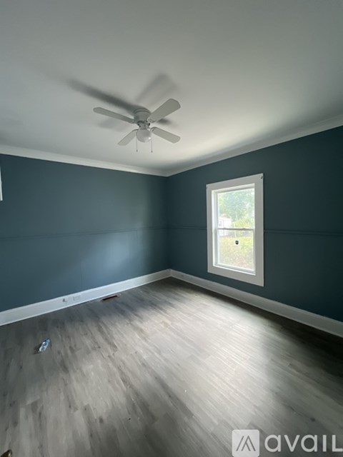 A room with a ceiling fan and a window.