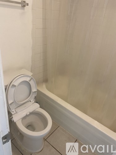 A toilet with the seat up in a bathroom.