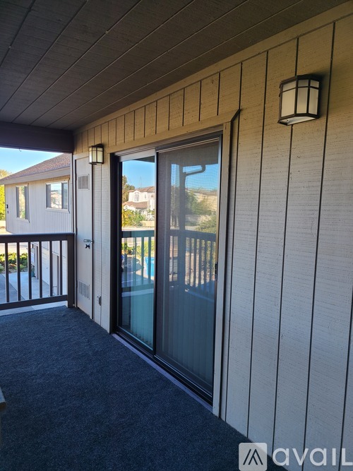 A balcony with a glass door and a lantern on the wall.
