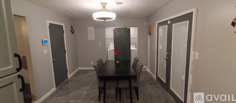 A dining room with a table and chairs.