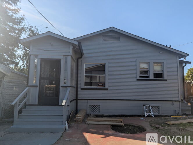 A house with a grey siding and a black door is for sale.